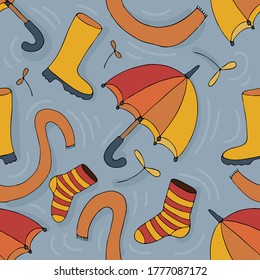 autumn rainy weather items on a puddle background - yellow and orange umbrella, rubber boots scarf on a blue background in doodle style, vector seamless pattern