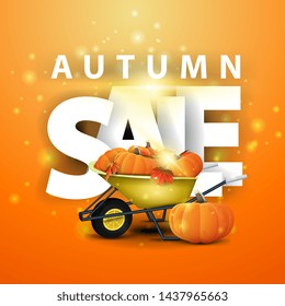 Autumn sale, orange discount banner with garden wheelbarrow with a harvest of pumpkins and autumn leaves