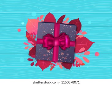 Autumn sale promotion design template with gift box, bow and leaves under it on blue background. Bright fall vector illustration for poster, card, label, banner.