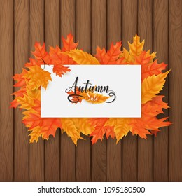 Autumn sale square background included a white board rounding by multiple leaves over the brown plank wood ,middle put a text of autumn theme