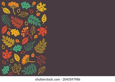 Autumn themed copy space with Fall leaves and berries in bright contrast red, yellow and green colors on a dark rich brown background