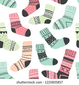 Autumn vector seamless pattern with cute colorful socks on white. Funny doodle socks with different patterns. Cute winter and autumn holidays hygge textile design in scandinavian style