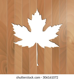 Autumnal Maple Leaf silhouette on a wooden background