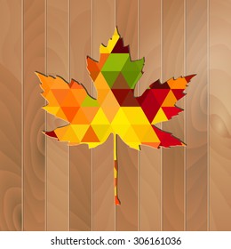 Autumnal Maple Leaf triangle on a wooden background
