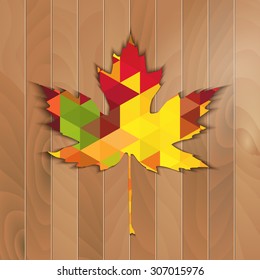 Autumnal Maple Leaf triangle on a wooden background