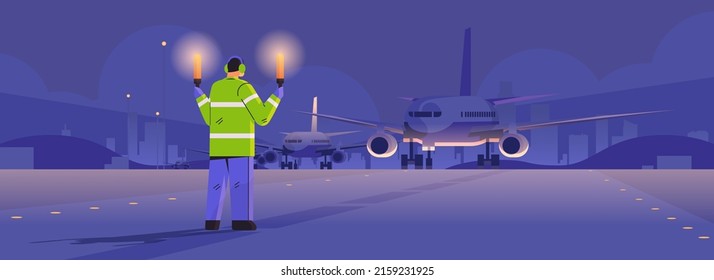 aviation marshaller with light sticks near aircraft air traffic controller airline worker in signal vest professional airport staff