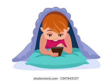 baby in bed under the blanket looking at the smartphone. boy can not leave the phone and fall asleep.