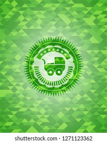 baby cart icon inside green emblem with mosaic background