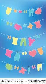  Baby clothes and toys dry on a rope on the sky background