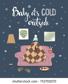 baby its cold outside handwritten quote, cute humor winter card with person sitting on couch under blanket at home