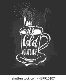 Baby its cold outside.Handwritten ink Lettering on hot drink cup shape coffee tea cocoa hot chocolate. Calligraphy style romantic winter quote on cup silhouette isolated on black chalkboard