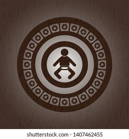 baby icon inside badge with wood background