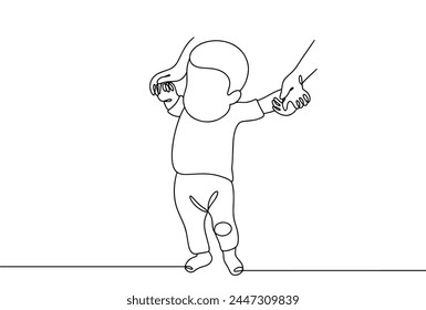 The baby stands on his feet and takes his first steps holding the hands of an adult. Child development up to one year.