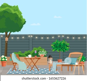 Back patio with garden furniture on a background of green plants.