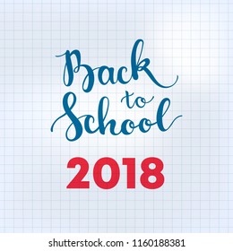 Back to school 2018 brush lettering on a grid sheet on exercise book. School square card with hand drawn inscription "back to school 2018" and freehand doodles of school supplies drawn by chalk