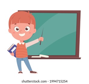 Back to school concept. Cheerful schoolboy holding pointer and a book and standing near blackboard