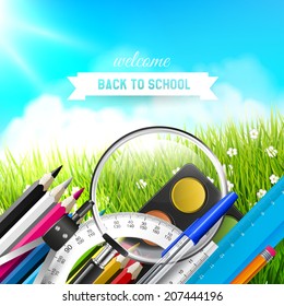 Back to school - modern background with school supplies on the grass