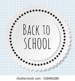 Back to school round label with dots on a checkered paper background.