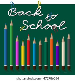 back to school, white text with paper clips on green chalkboard - pencils set, twelve colored crayons and shadow