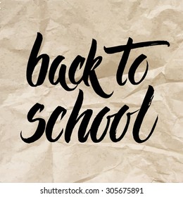 Back to school words hand written by brush, black over brown crumpled paper.