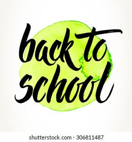 Back to school words hand written by brush, black over yellow-green watercolor circle.