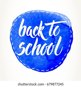 Back to school words hand written by brush, white over dashed blue watercolor circle.