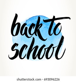 Back to school words hand written by brush, black over blue watercolor circle.
