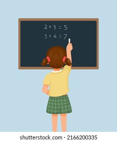 Back view of cute little girl student write on blackboard math equation in front of class with chalk