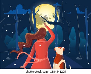 Back View of Woman and Dog Watching Santa Riding Reindeer Sleigh on Blue Forest Full Moon Night Background for Merry Christmas & New Year Celebration.
