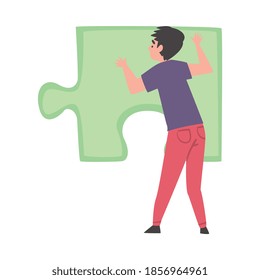 Back View of Young Man Solving Jigsaw Puzzle, Guy Trying to Connect Big Green Puzzle Element Cartoon Style Vector Illustration