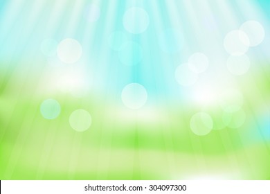 Background with bokeh effect and sun rays for your design , the blue sky and green grass background
