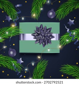 Background greetings top view  with fur tree branches, garland and  gift in center. Christmas concept decoration  on trendy dark blue background.