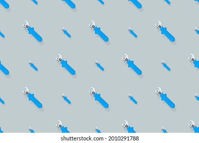 Background from a metal adjustable wrench with a rubber handle. Tools seamless pattern.