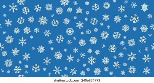 A background of snowflakes dotted randomly across a blue canvas. Background of snowflakes of different sizes and types, seamless and New Year's pattern.