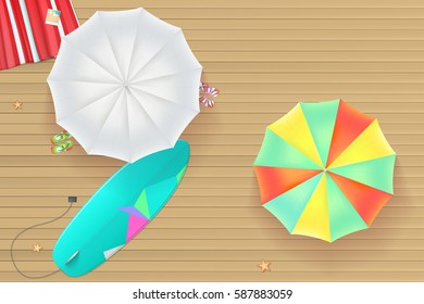 Background for summer holidays. Colored sun umbrellas, surfboard, flip-flops and a beach Mat on the wooden background from light brown straps. Tropical seashore, top view. Summer travel background.