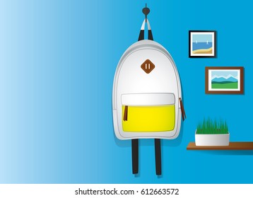 Backpack on wall with pictures and grass.
