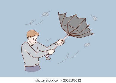 Bad weather and storm concept. Young stressed man cartoon character standing trying to catch flying umbrella from rain and wind vector illustration 