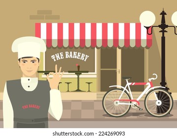 Baker in uniform on the background of a small town bakery shows excellent hand sign