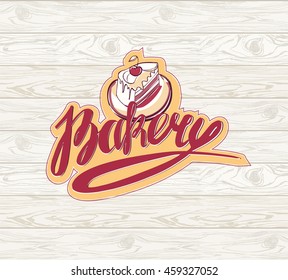 Bakery logotype with sketch cake and hand drawn lettering bakery. Isolated on wooden seamless background