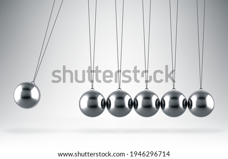Balancing balls Newton's cradle hanging on gray background