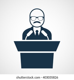 Bald-headed man at rostrum - speaker in glasses at tribune