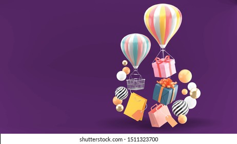 Balloon, gift box and shopping bag surrounded by colorful balls on a purple background.
