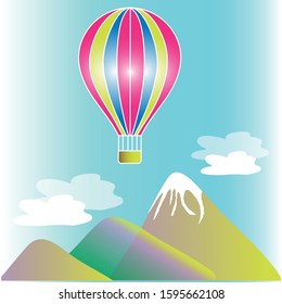 Balloon in the sky above the clouds and mountain peaks