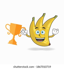 Banana mascot character with a trophy in right hand. vector illustration