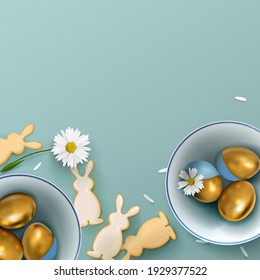 Banner with golden Easter eggs in a ceramic bowl with flowers and cookies in the form of hares on the background. Easter decoration on a blue background.