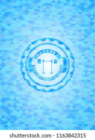 barbell on rack icon inside light blue emblem. Mosaic background