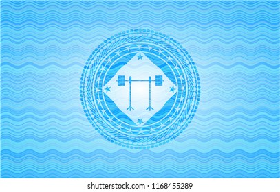 barbell on rack icon inside sky blue water wave badge.