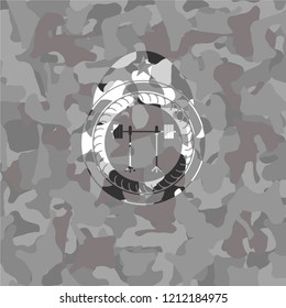 barbell on rack icon inside grey camouflaged emblem