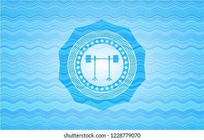 barbell on rack icon inside water wave badge.