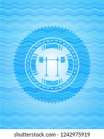 barbell on rack icon inside light blue water badge.